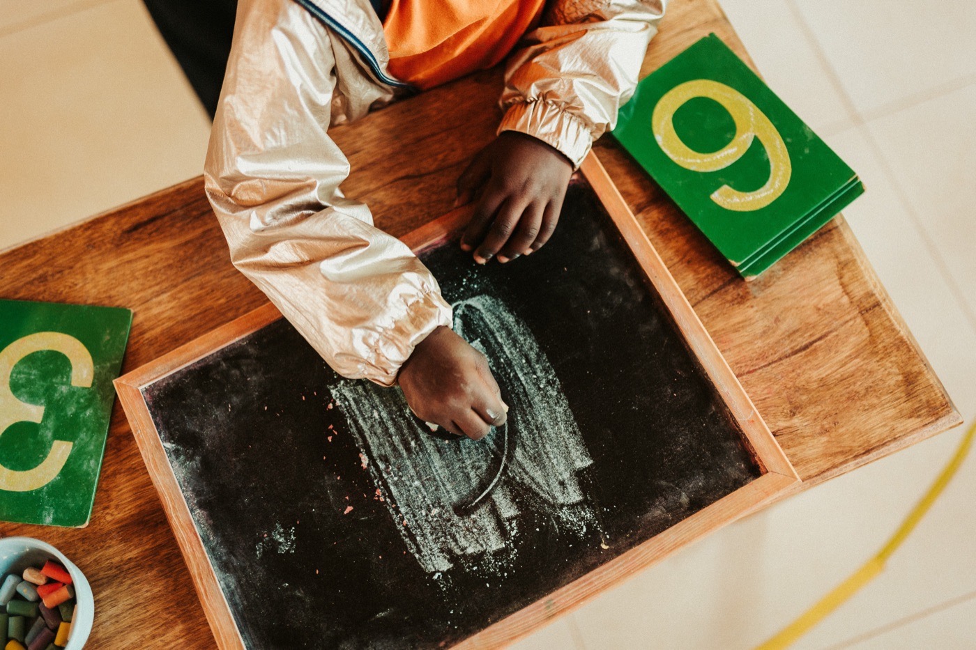 Main d'enfant traçant les lettres rugueuses